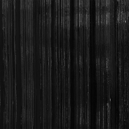 Close-up of black vertical streaks with subtle texture on a wallcovering, resembling brushed metal or dark wood grain for a modern industrial look.