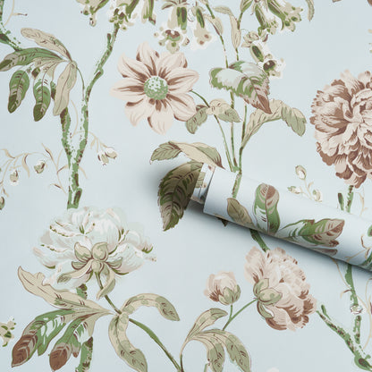 Light blue wallpaper with vintage botanical floral pattern in cream, pink, and green; rolled edge shows design repeat.