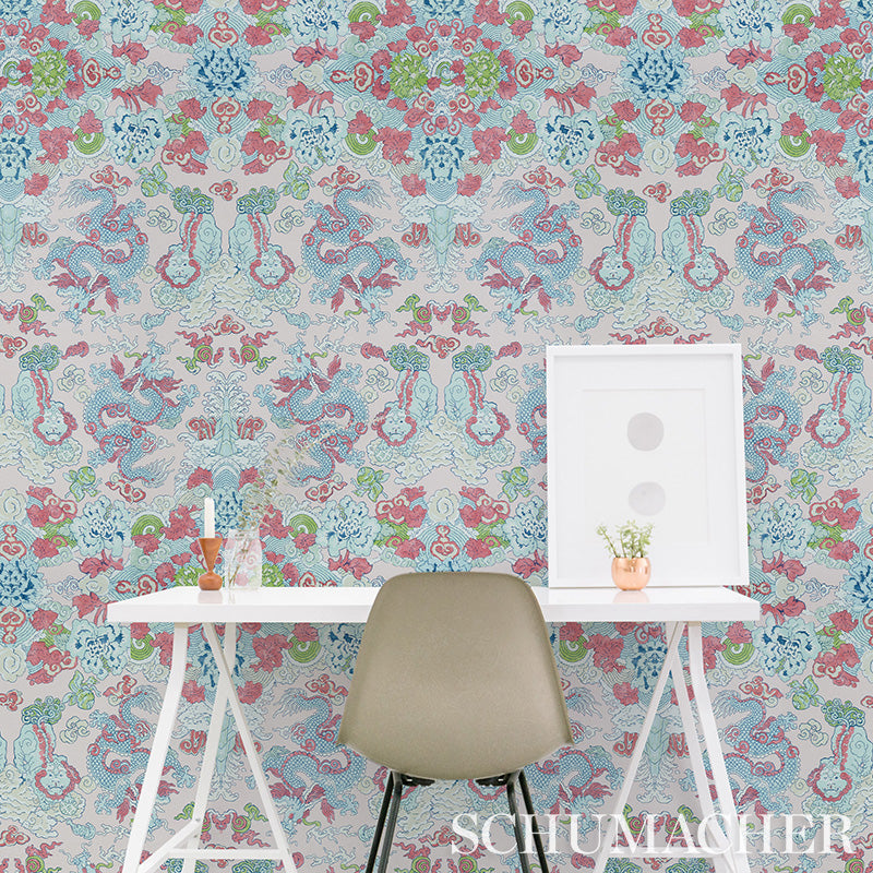 Chic home office scene with chinoiserie wallpaper, white desk, beige chair, framed art, small plant in copper pot.