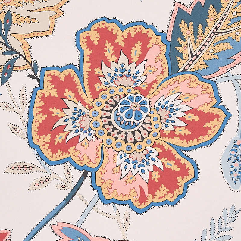 Close-up of vibrant floral fabric with large orange-red petals outlined in blue and a blue-white center on beige.