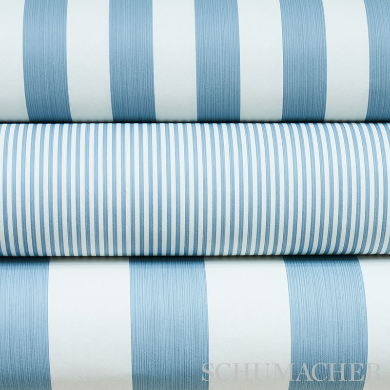 Stack of blue and white striped fabric rolls, varying stripe widths, light cotton textiles suitable for shirts or linens.