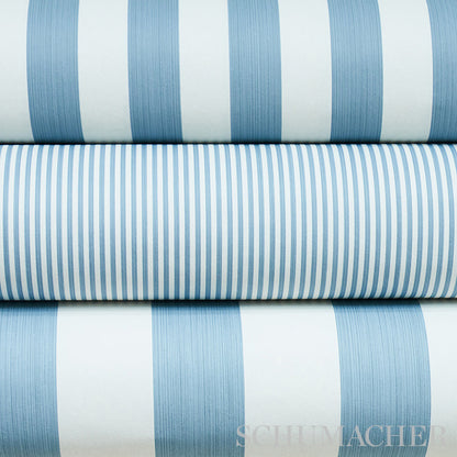Stack of blue and white striped fabric rolls, varying stripe widths, light cotton textiles suitable for shirts or linens.