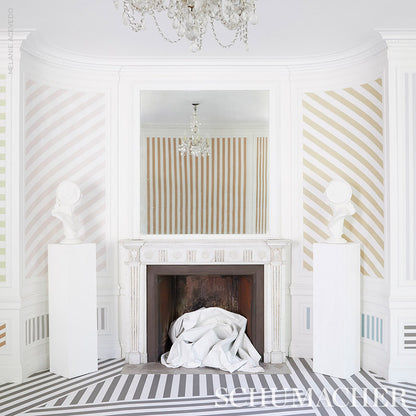 Elegant white ornate fireplace with pastel striped walls, busts on pedestals, chandelier, and fabric draped in the hearth.