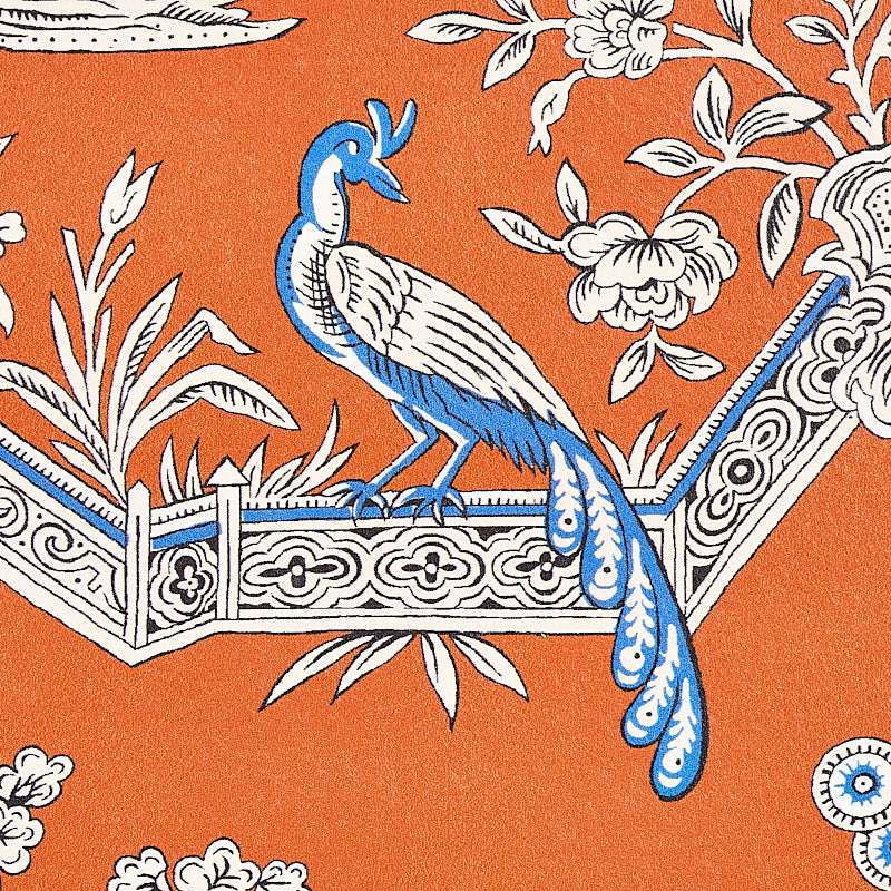 Blue and white peacock perched on an ornate rail with floral motifs against an orange background; textile print.