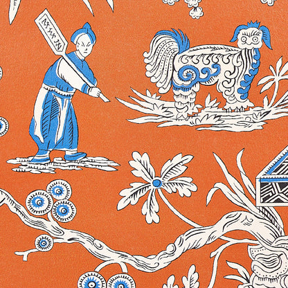 Orange batik-style textile with blue-white dragon, robed figure holding a banner, & flowering branch motif.