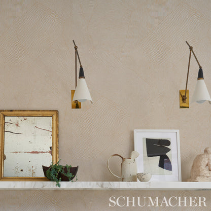 Beige textured wall with two white-cone wall sconces, marble shelf, plant, ceramic pitcher, and gold-framed artwork.