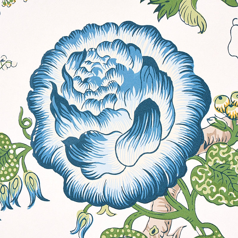 Large blue floral bloom with green vines on cream background; vintage botanical pattern.