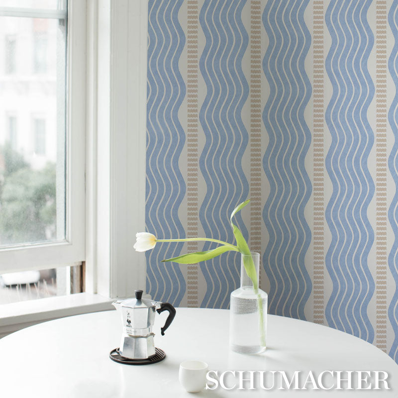 Round white table by window with blue wavy-striped wallpaper; moka pot on tray, white tulip in glass bottle, white cup.