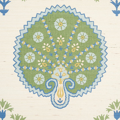 Sisal green rug with a stylized tree/peacock motif in olive green, white and yellow flowers, blue outlining and a zigzag border.