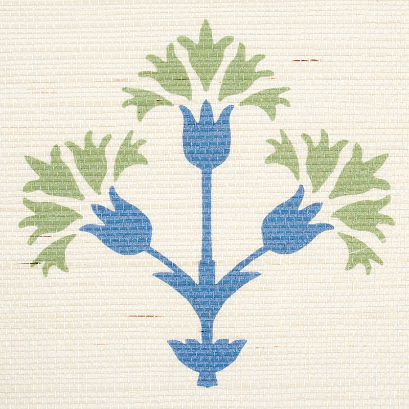 Green sisal rug with a blue three-branch floral motif and green leaves.