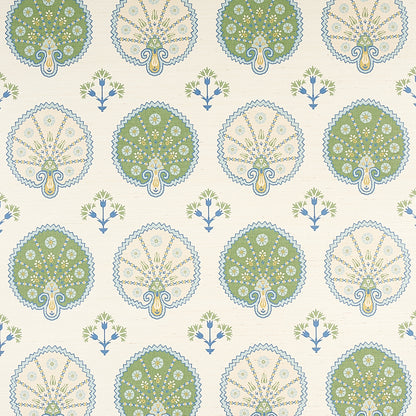 Wallpaper pattern of green and beige tree medallions with blue scalloped borders, interspersed by small blue flowers on cream.