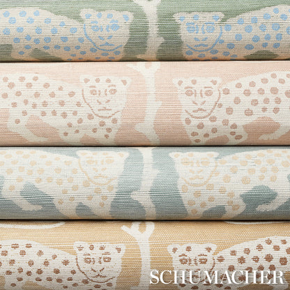 Stacked pastel fabric rolls featuring owl and dot motifs in mint, pink, blue and beige (Schumacher watermark).