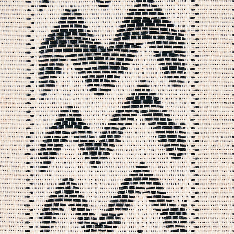 Beige woven fabric with bold black chevron zigzag pattern; textured geometric textile.