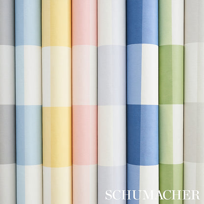 Rows of wallpaper rolls with a large plaid check in seaglass and pastel tones; blue, yellow, pink, gray and green; Schumacher watermark.