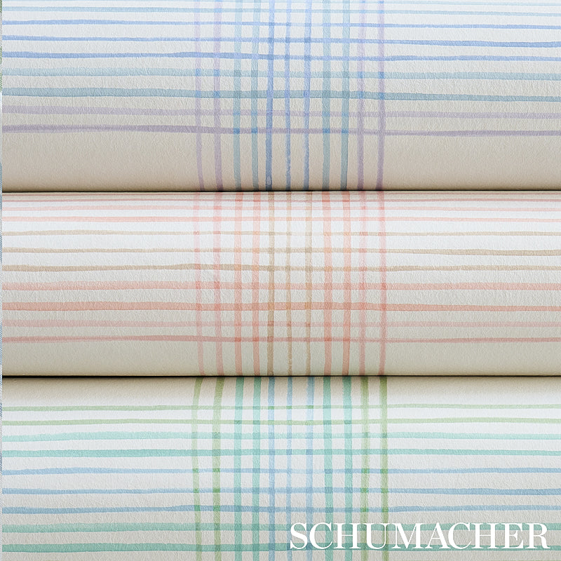 Pastel plaid wallpaper rolls in blue, peach and green, stacked horizontally; textured paper for home decor.