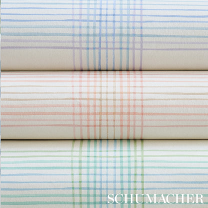 Pastel plaid wallpaper rolls in blue, peach and green, stacked horizontally; textured paper for home decor.
