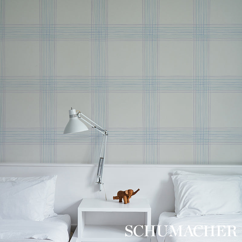 Minimalist white bedroom with twin beds, adjustable silver lamp on nightstand, brown plush elephant, blue plaid wallpaper.