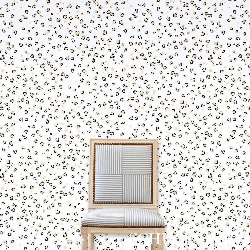 Leopard print wallpaper backdrop with a light wood-framed chair featuring a patchwork striped backrest and cushioned seat.