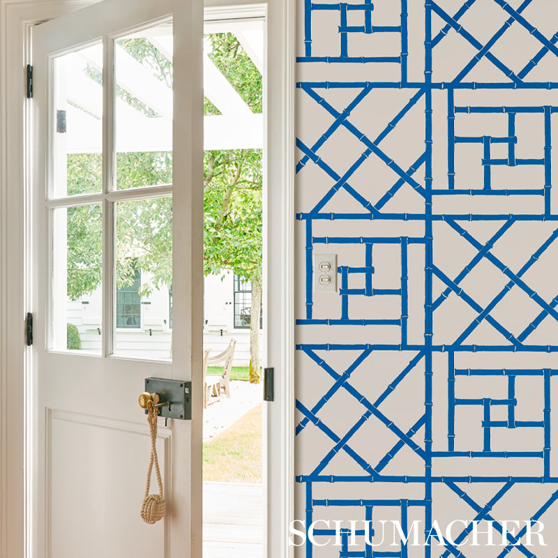 Indigo trellis wallpaper on wall with a repeating lattice pattern.