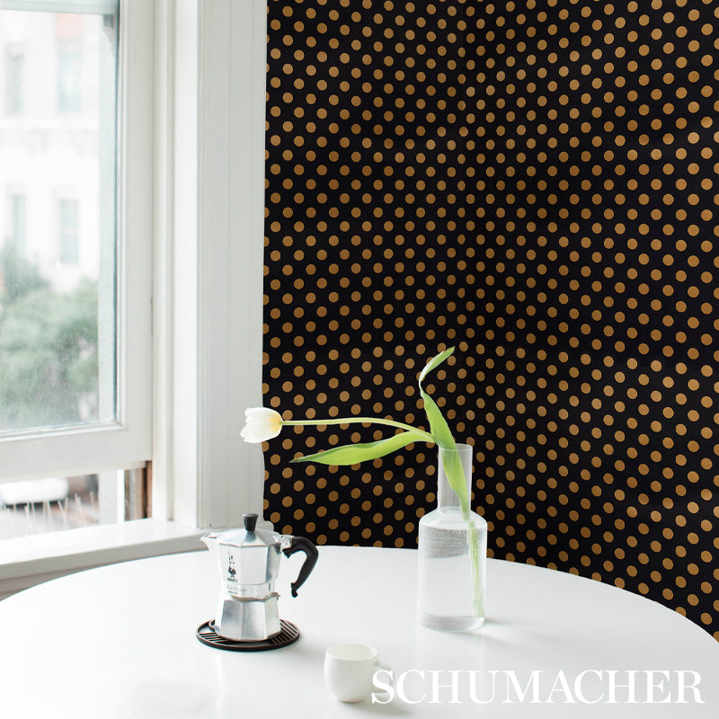 Vase with white tulips against black and gold polka-dot wallpaper.