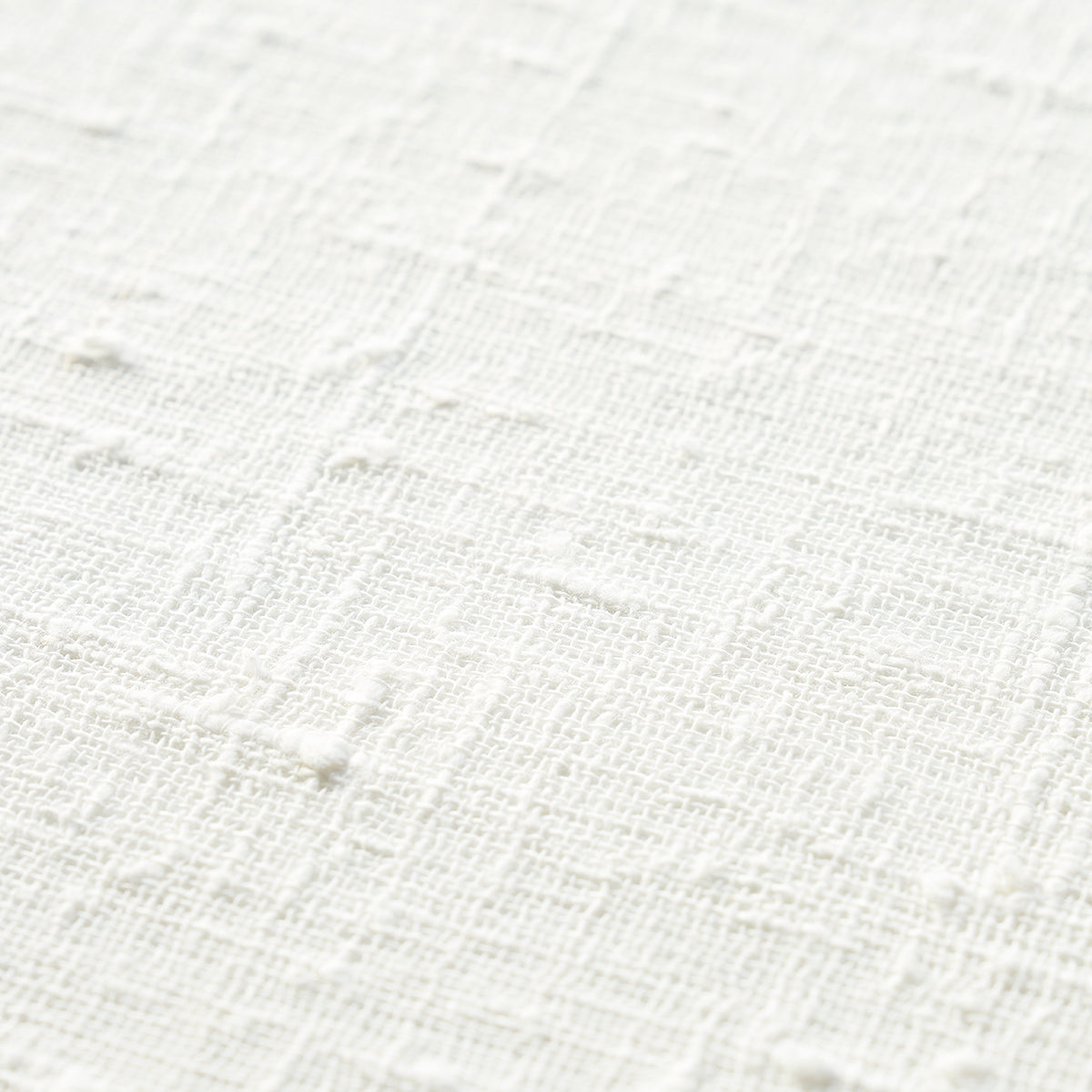 White textured fabric close-up with a subtle raised grid pattern; linen/cotton look.