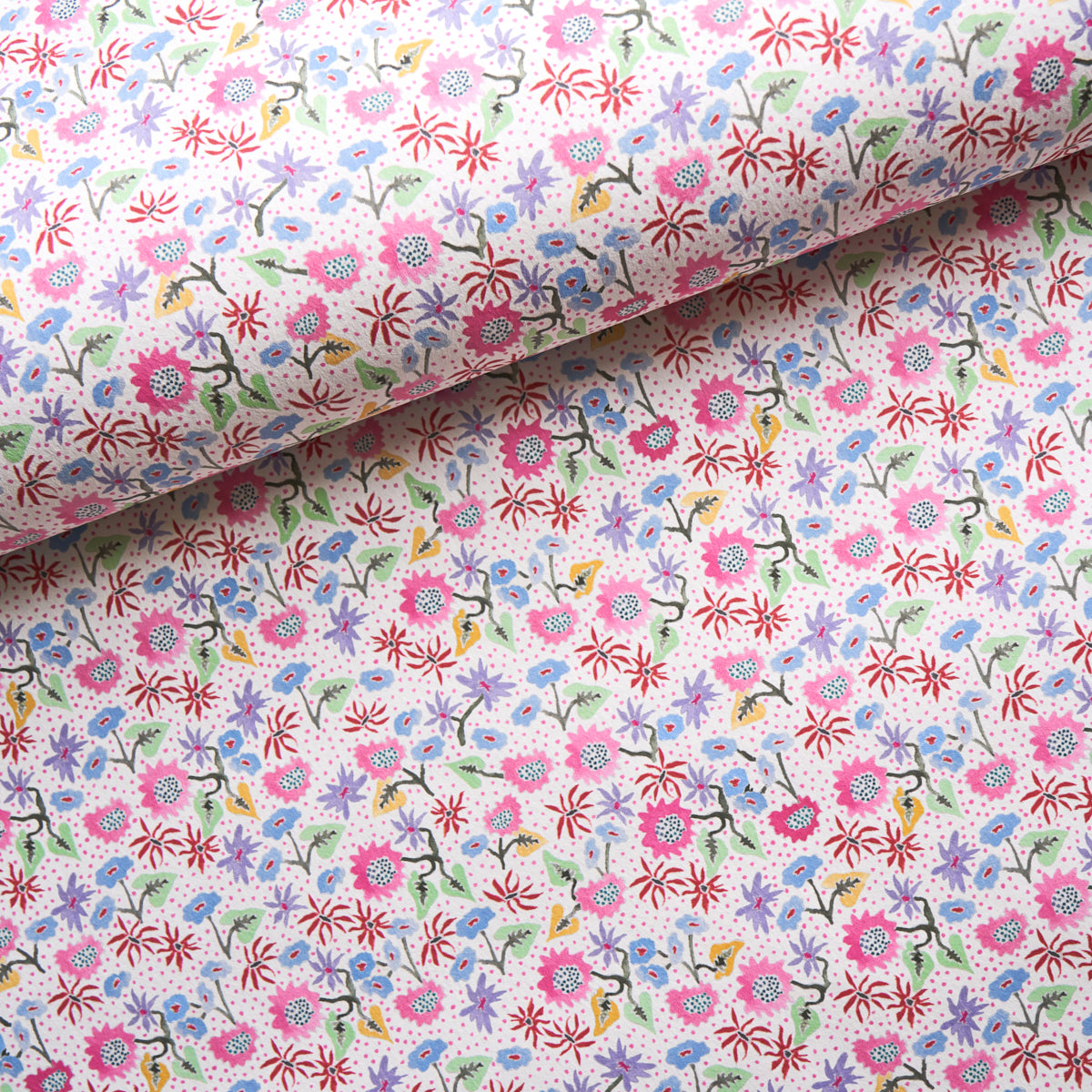 Floral cotton fabric with tiny pink, purple, blue flowers and green stems against white backdrop, rolled