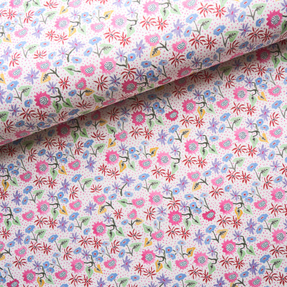 Floral cotton fabric with tiny pink, purple, blue flowers and green stems against white backdrop, rolled