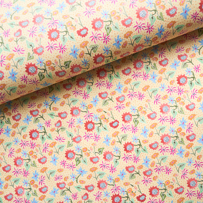 Beige calico fabric with a tiny multicolor floral print (pink, red, blue, green) and vines; rolled at top.