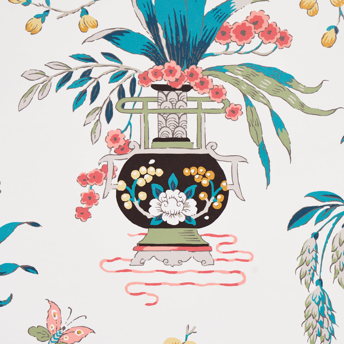 Ornate black ceramic vase with white floral motif & green handles, on a green pedestal with blue & pink blooms