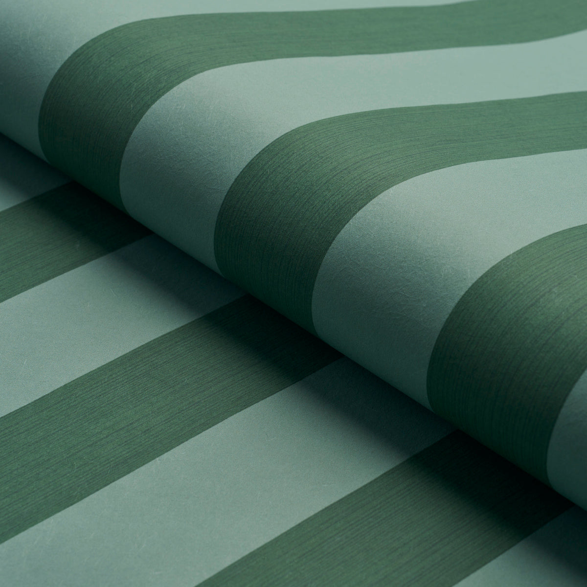 Close-up of green striped wallpaper in mint & emerald tones, rolled with curved edges.