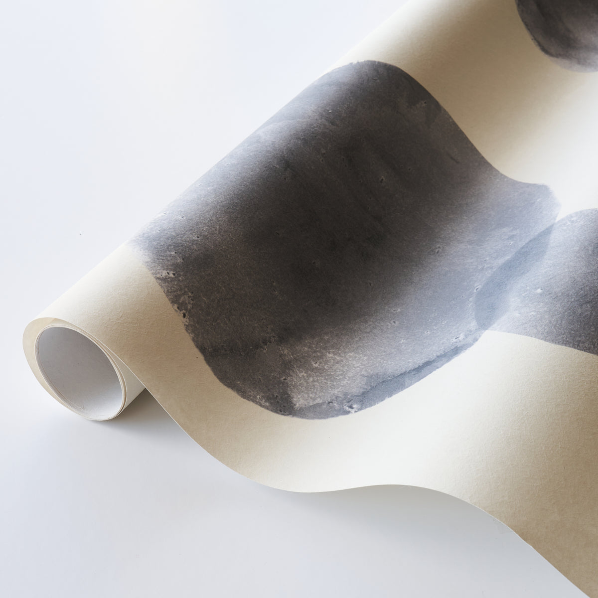 Rolled cream poster featuring a bold black abstract brushstroke, parchment-like finish, modern wall art.
