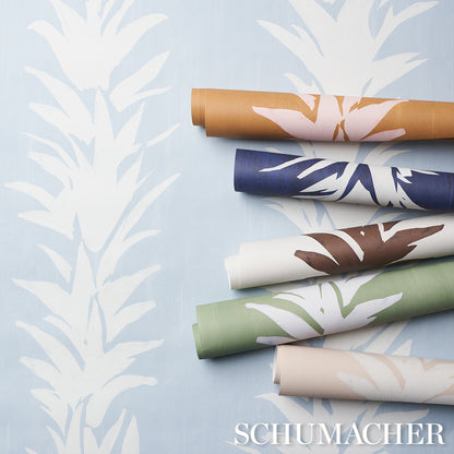 Rolled wallpaper samples showing a white lotus motif on a deep yellow background.