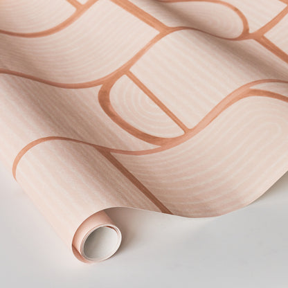Pastel pink wallpaper with peach rounded-rectangle geometric motif, rolled sample.