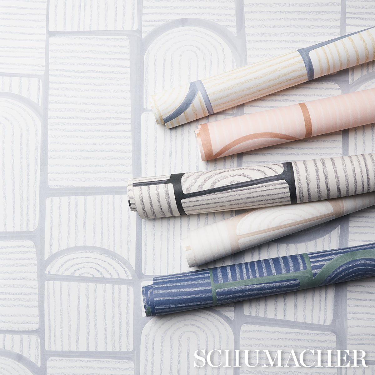 Assorted wallpaper rolls featuring wood-grain and geometric patterns in blue, gray, peach and beige.