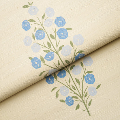 Beige sisal wallpaper with blue floral print, green stems and leaves; rolled fold showing delicate blossom pattern.