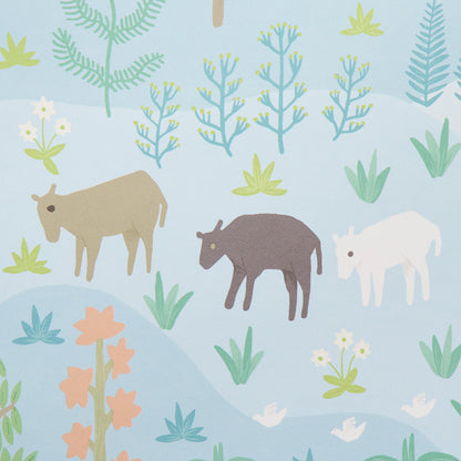 Pastel illustrated pattern on fabric featuring tan, dark brown and white horse-like animals among blue hills and leafy plants.