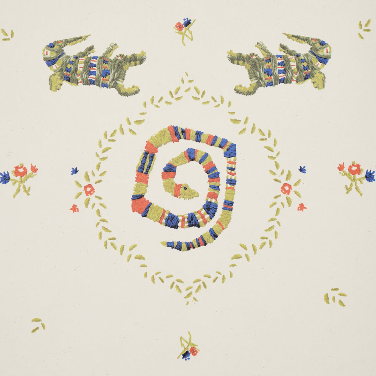 Textile print: concentric multicolor spiral garland, yellow leaf border, florals, and mirrored green lizard motifs on cream.