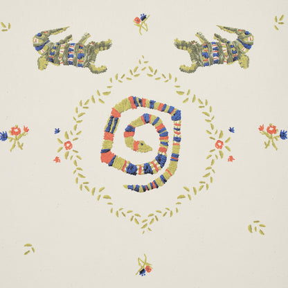 Textile print: concentric multicolor spiral garland, yellow leaf border, florals, and mirrored green lizard motifs on cream.