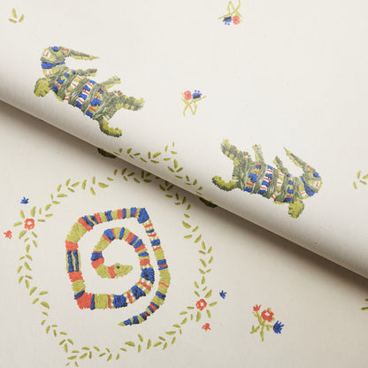 Cream wallpaper with multicolor knitted-look crocodile motifs, circular laurel wreaths, and tiny flowers.