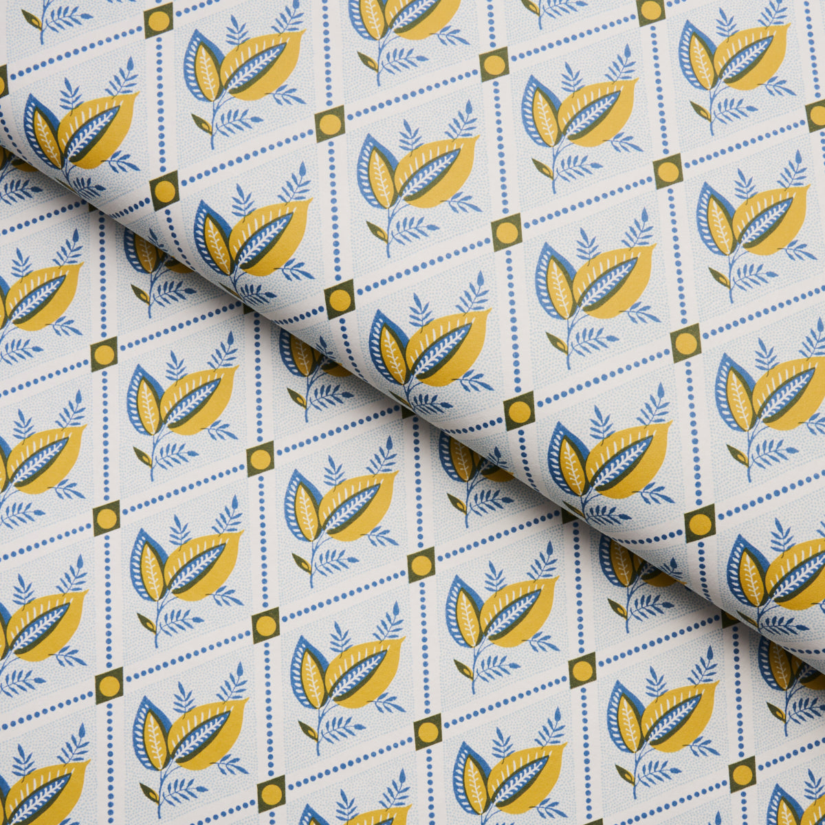Fabric with blue and yellow botanical leaves in diamond grid on white background; decorative textile for crafts or apparel.
