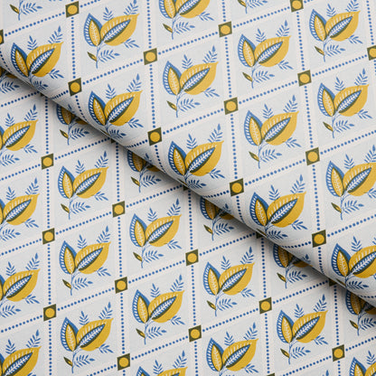 Fabric with blue and yellow botanical leaves in diamond grid on white background; decorative textile for crafts or apparel.