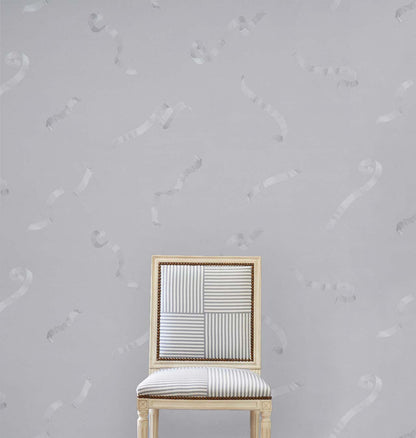 Grey upholstered chair with a patchwork striped back, cushioned seat, and gold trim.