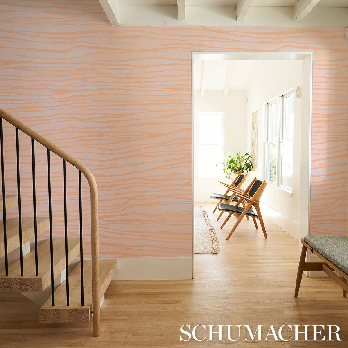 Peach wall panels with soft orange wavy stripes; wooden staircase and a bright sunlit living room with mid-century chairs.