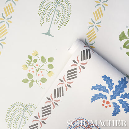 White wallpaper sample with blue leaf motif and red berries; rolled edge reveals black striped border with pink floral accents.