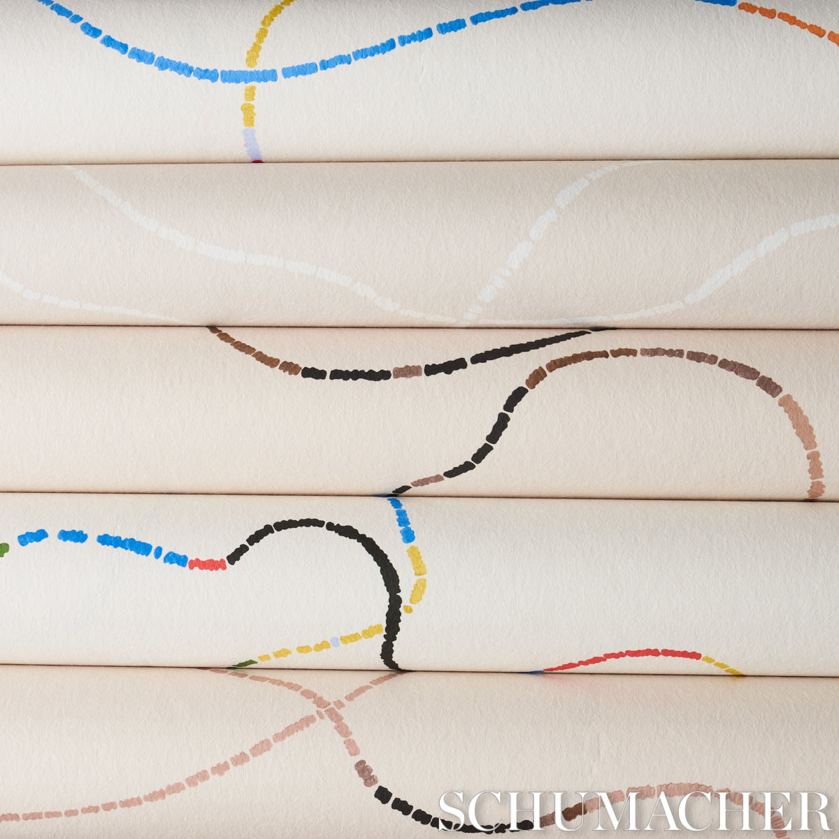 Cream fabric rolls stacked with colorful dashed arc patterns in blue, yellow, brown, black and red.