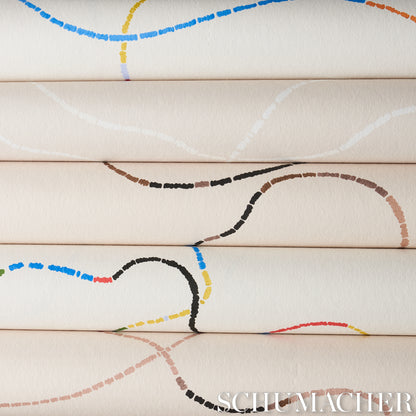 Cream fabric rolls stacked with colorful dashed arc patterns in blue, yellow, brown, black and red.