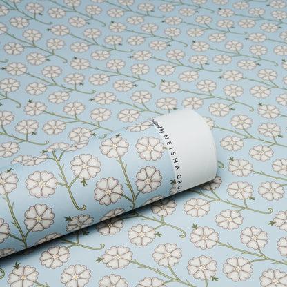 Light blue wallpaper featuring white five-petaled flowers and green stems; rolled sheet with botanical print.