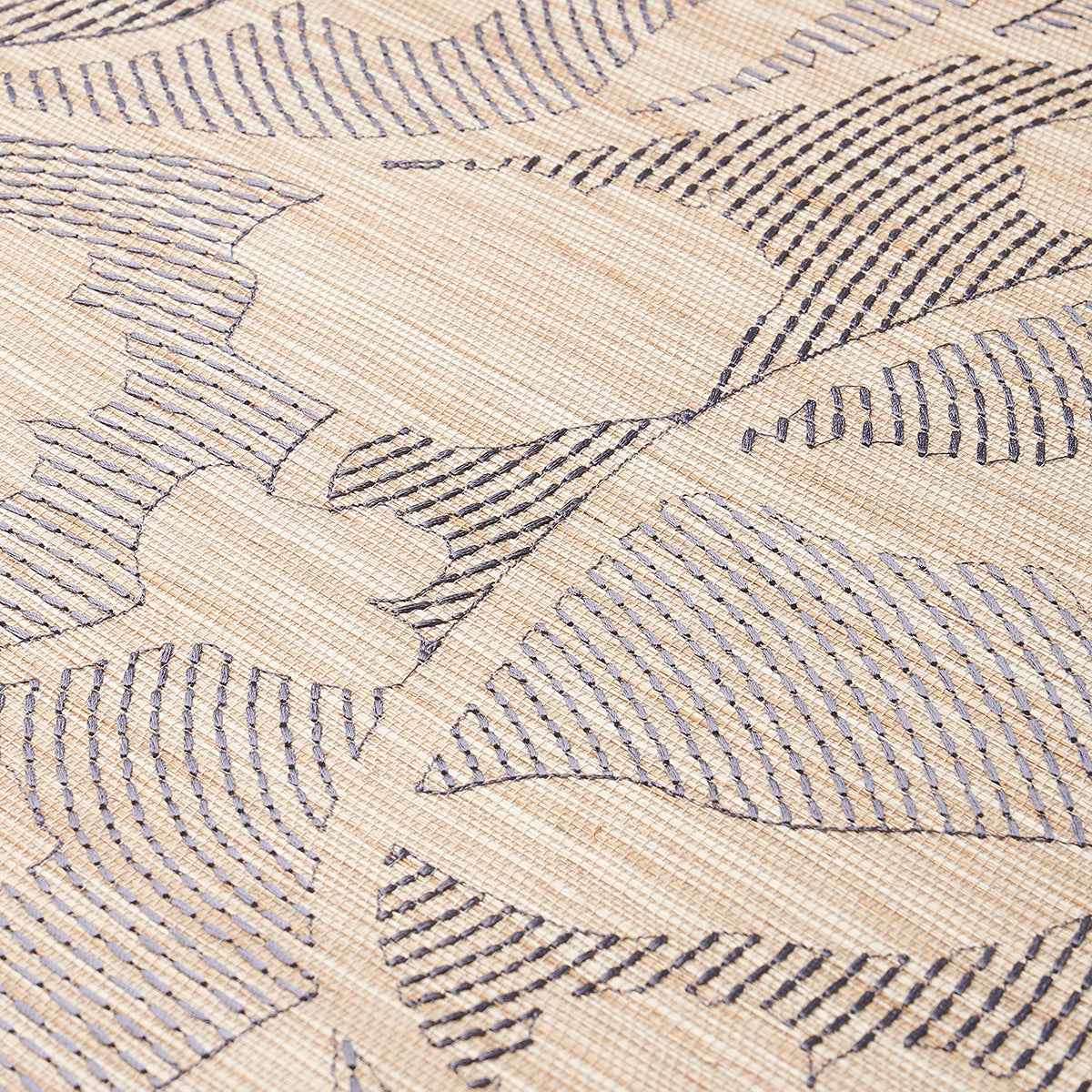 Beige woven fabric with navy leaf-shaped motifs and fine striped patterns; soft upholstery texture.
