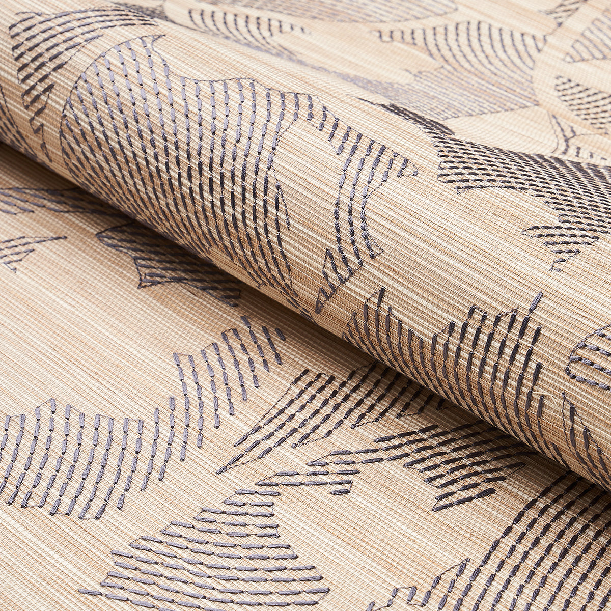 Beige woven fabric with dark blue abstract leaf motif, rolled on a bolt; upholstery or curtain textile.