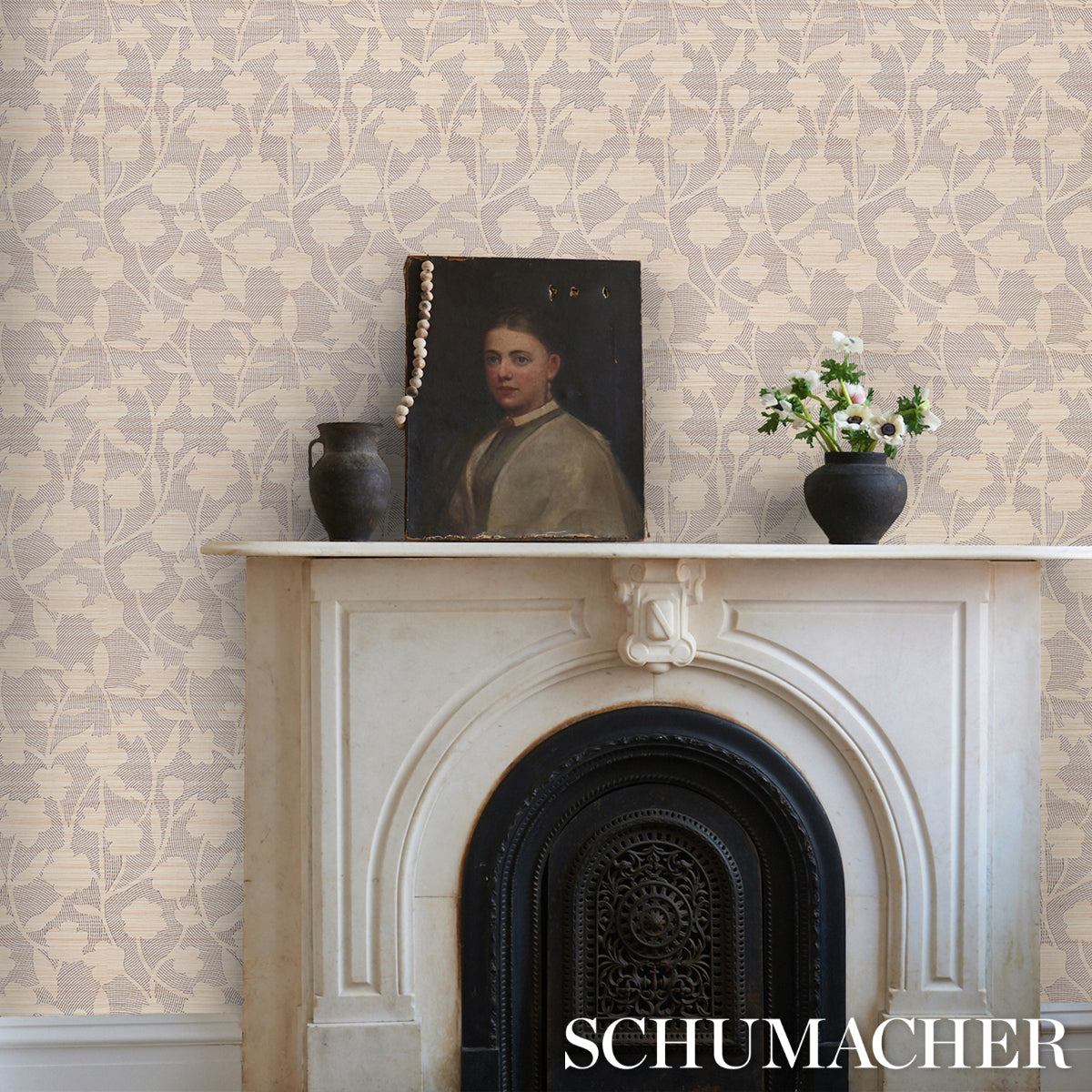 Beige floral wallpaper, white marble mantel with ornate arch and black surround; vintage portrait, pearl necklace, dark vase.